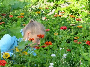 eine junge Frau kniet zwischen den Blumen