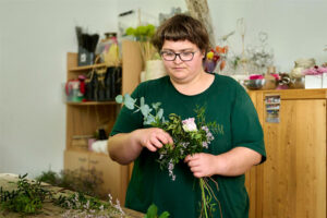eine junge Frau stellt einen Blumenstrauß zusammen